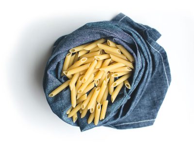 foodiesfeed.com_pasta-penne-in-blue-linen-on-a-white-background